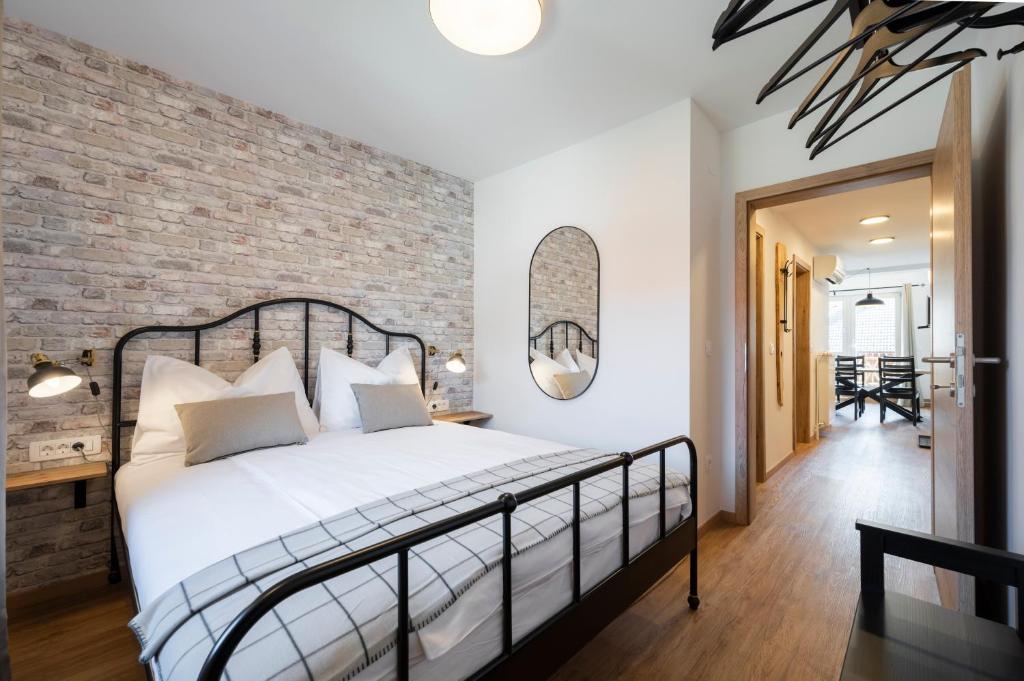 GrosAlp apartments في ليسْتْسي: غرفة نوم بحائط من الطوب وسرير