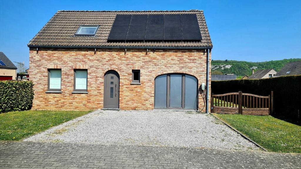 ein Backsteinhaus mit Sonnenkollektoren auf dem Dach in der Unterkunft Gîte au 14 - au calme avec jardin , proche de Dinant in Anhée