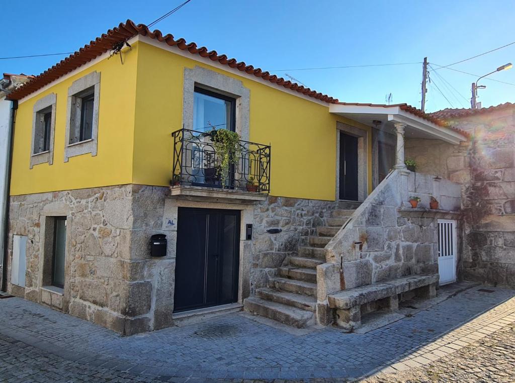 una casa amarilla con escaleras delante en Casa Beira Rio, en Viana do Castelo