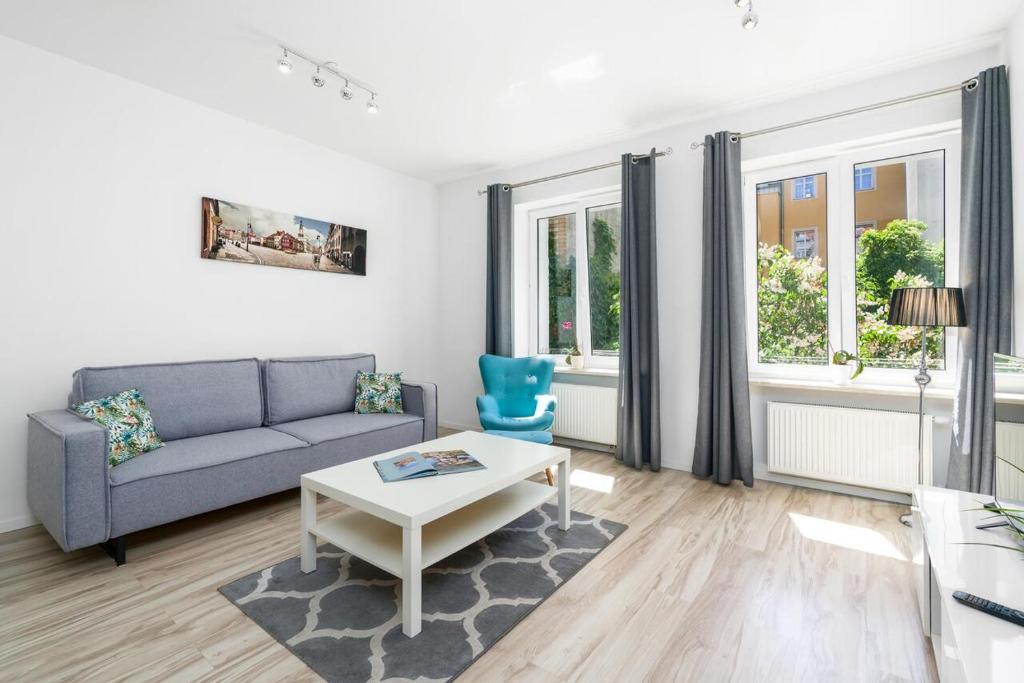 uma sala de estar com um sofá e uma mesa em Apartment and Rooms at Mostowa street em Poznań