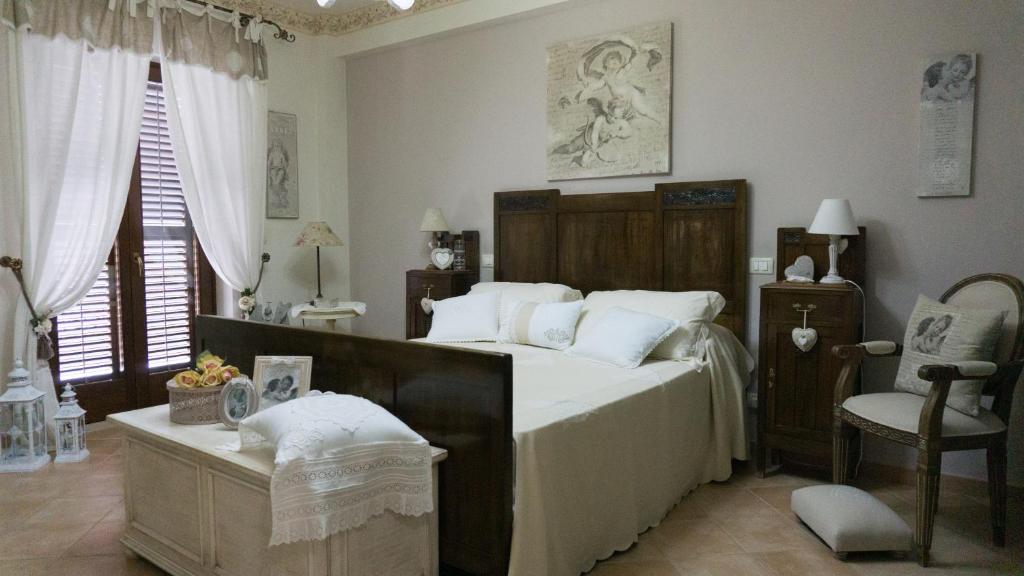 a bedroom with a large bed and a chair at La stanza della nonna in Modica