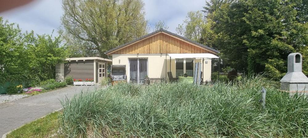 una pequeña casa en medio de un jardín en Haus Skye, en Großenbrode