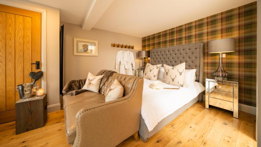 1 dormitorio con cama blanca y sofá en Nether Glenny Farm, en Stirling