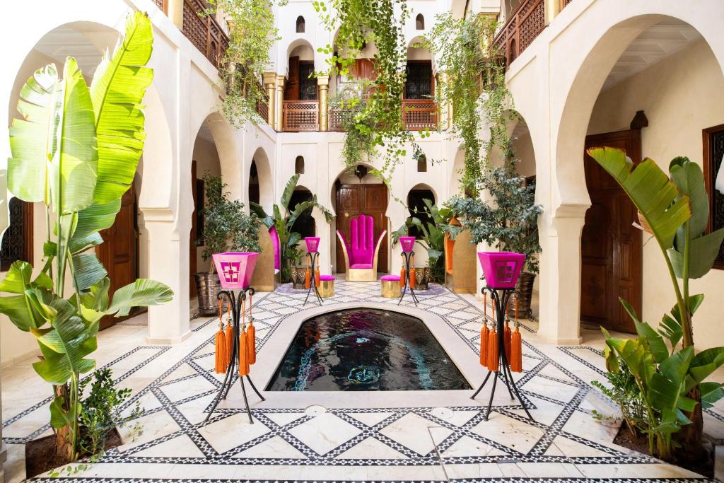 un cortile con piscina in un edificio con piante di Riad Wow a Marrakech