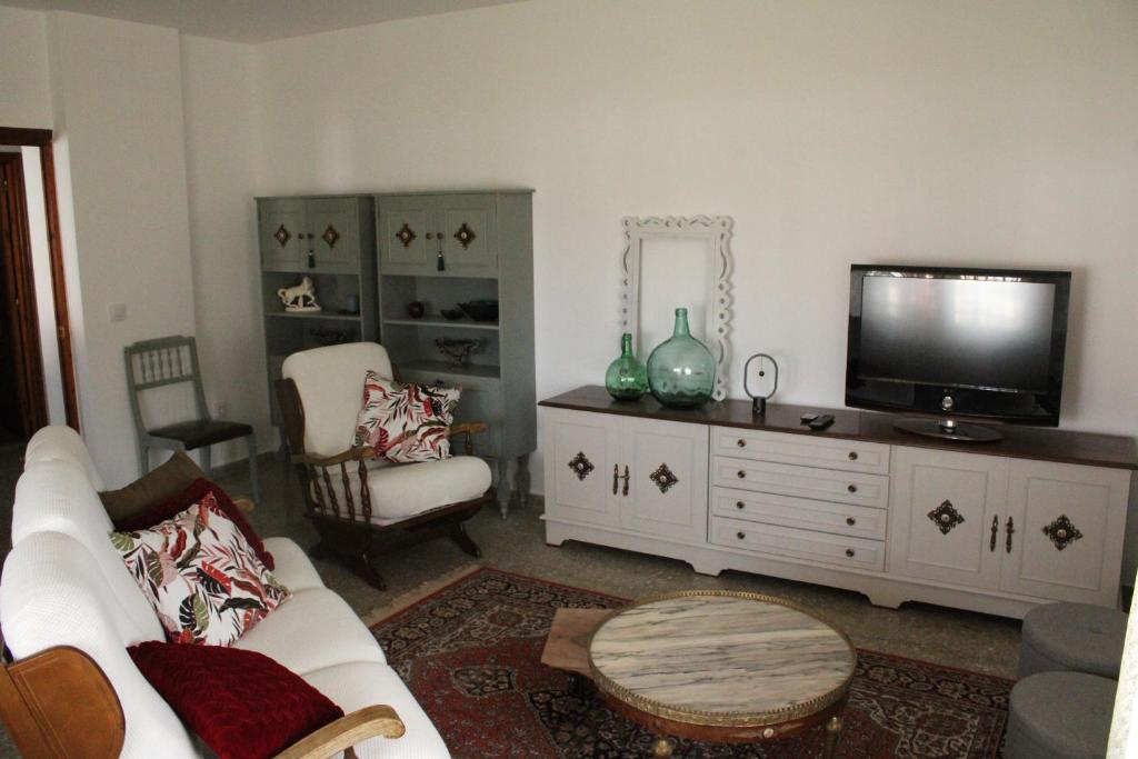 uma sala de estar com um sofá branco e uma televisão em ACAO Vivienda Uso Turístico ARRIBES del Duero em Moral de Sayago