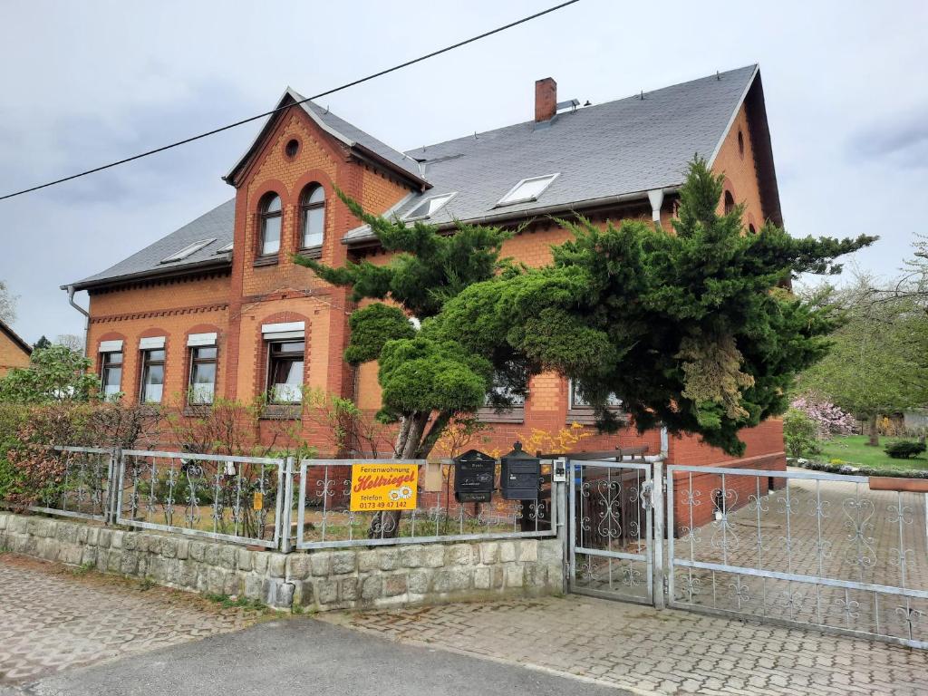 a brick house with a fence in front of it at Ferienwohnung Hellriegel in Weißwasser