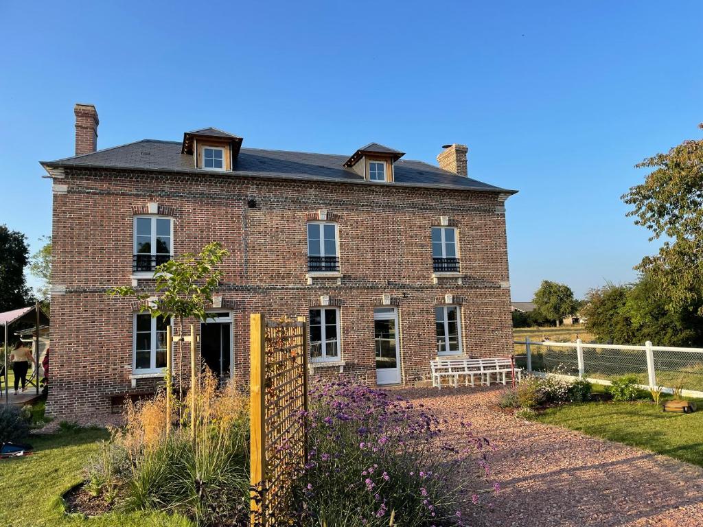 an old brick house with a garden in front of it at La Maison des Jonquerets in Jonquerets-de-Livet