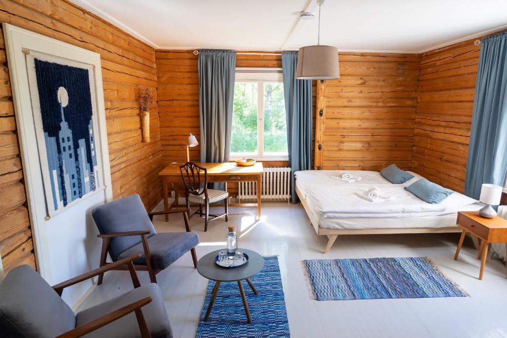 a bedroom with a bed and a table and chairs at Olo Center by Kolovesi Nature Park in Enonkoski