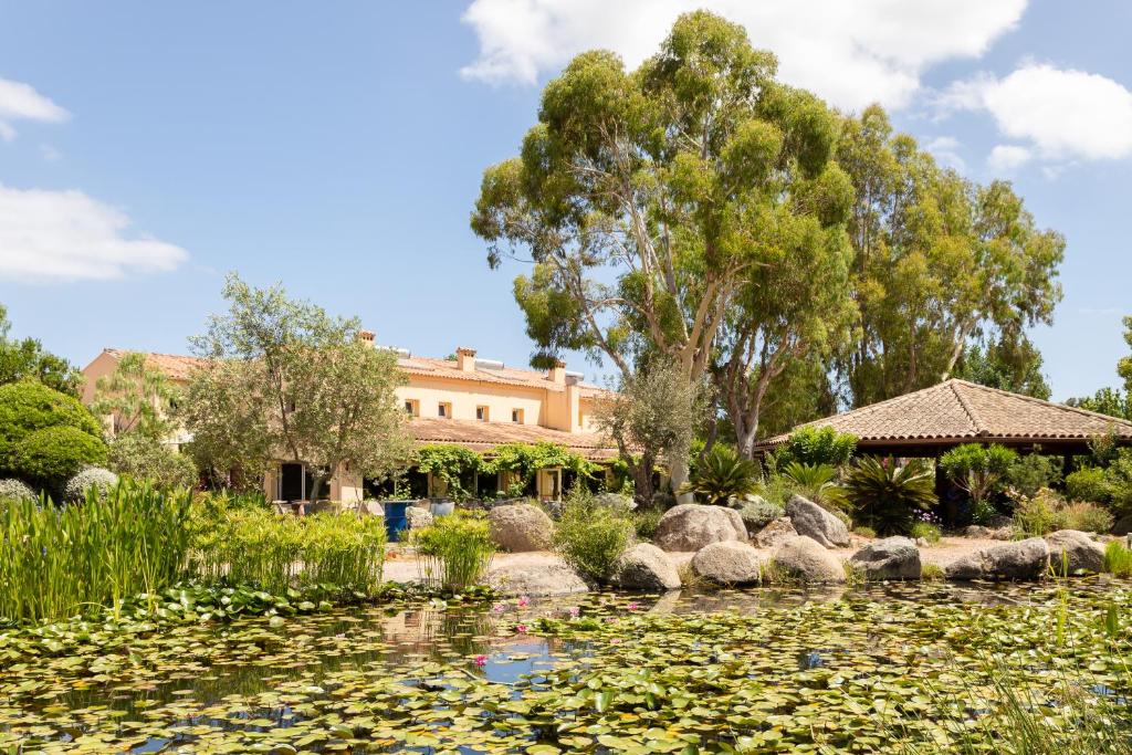 un étang avec des nénuphars devant un bâtiment dans l'établissement San Giovanni, à Porto-Vecchio