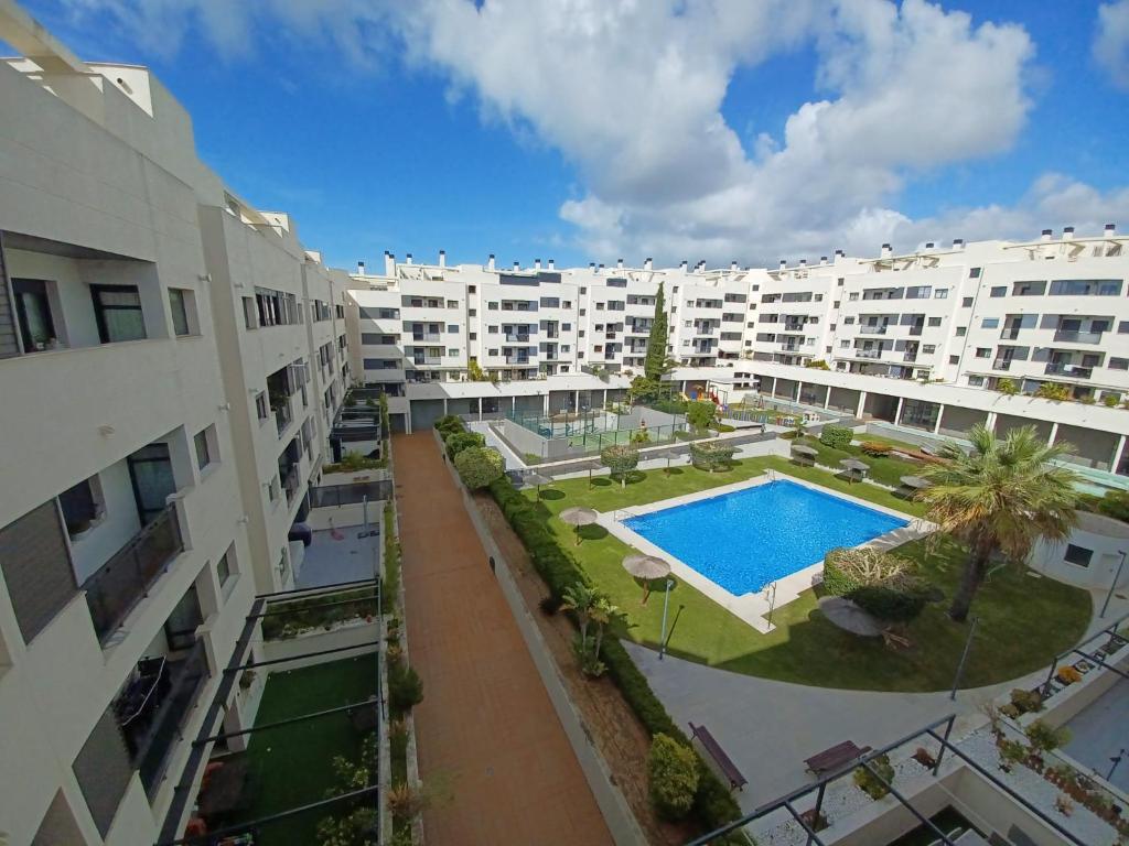 uma vista aérea de um complexo de apartamentos com uma piscina em Magnífico apartamento en El Pto de Sta María, aire acc, piscina, zona niños y padel em El Puerto de Santa Maria