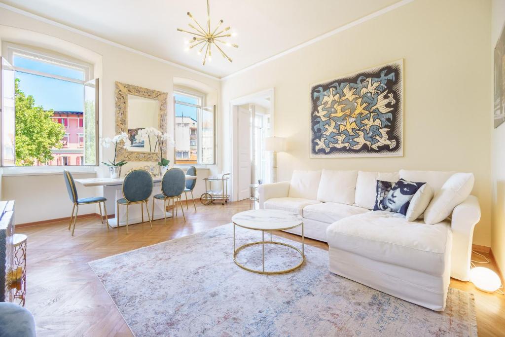 a living room with a white couch and a table at James Joyce Luxury Apartment in Trieste