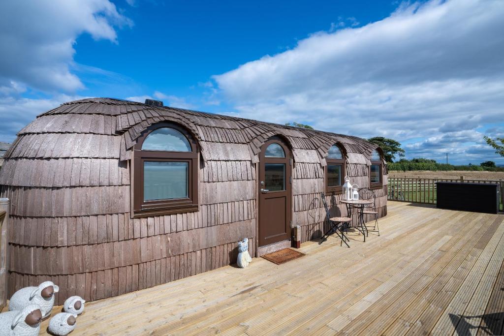 a large wooden yurt with a wooden deck at "Lammermuir" Rock & Castle Escapes in Whitekirk
