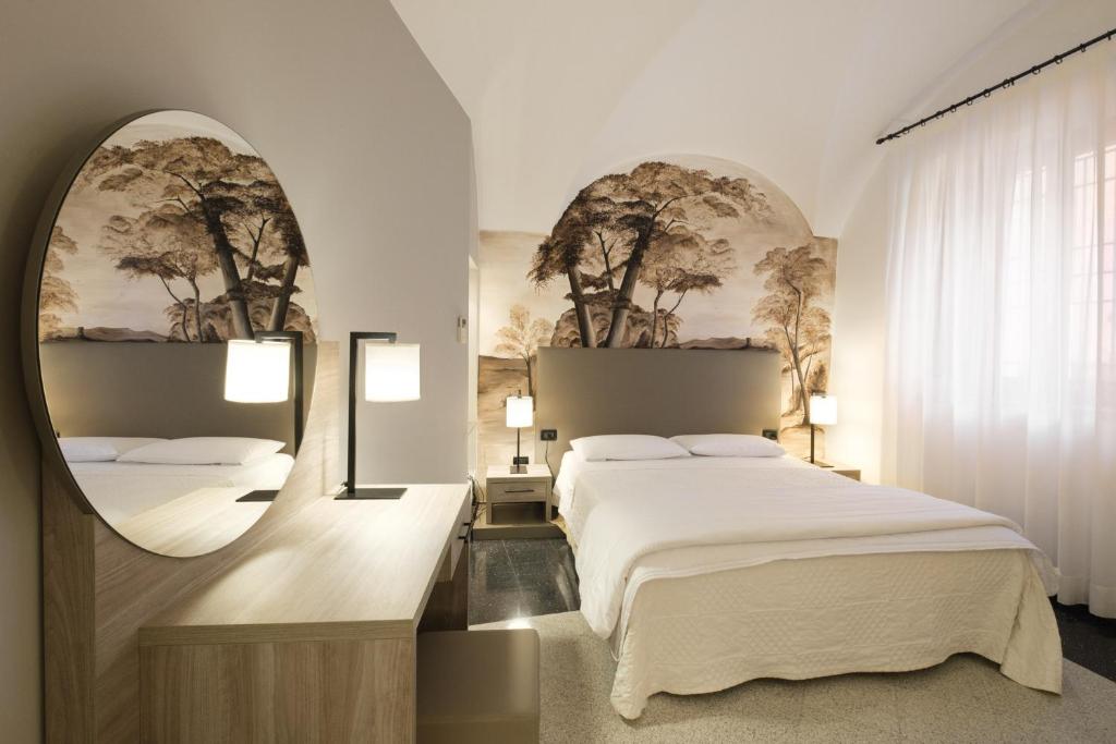 a bedroom with a large bed and a mirror at Hotel Ristorante Alla Vittoria in Solferino