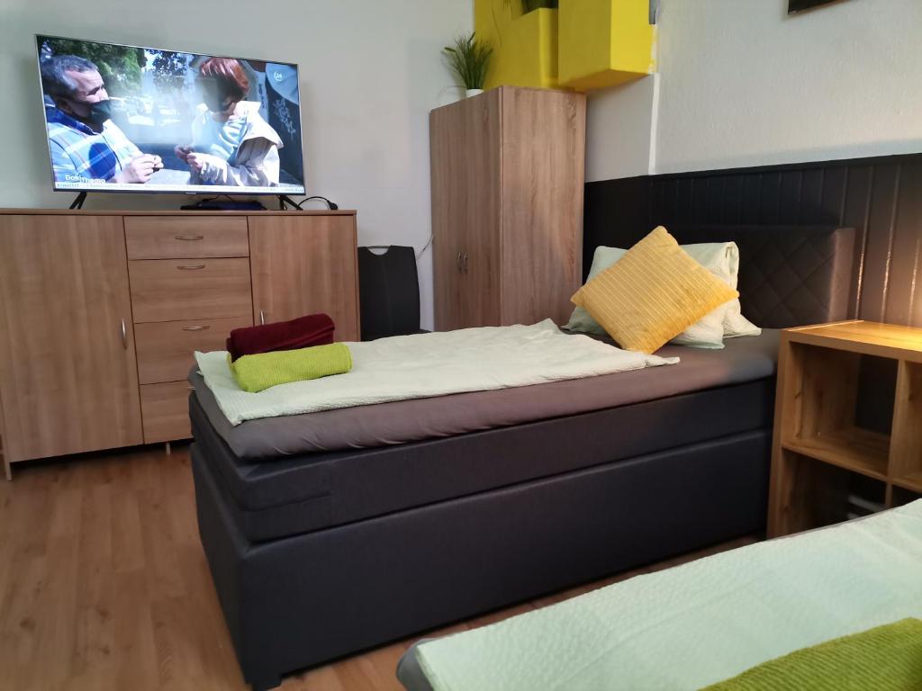 Habitación pequeña con cama y TV. en Pension Prem en Kapfenberg
