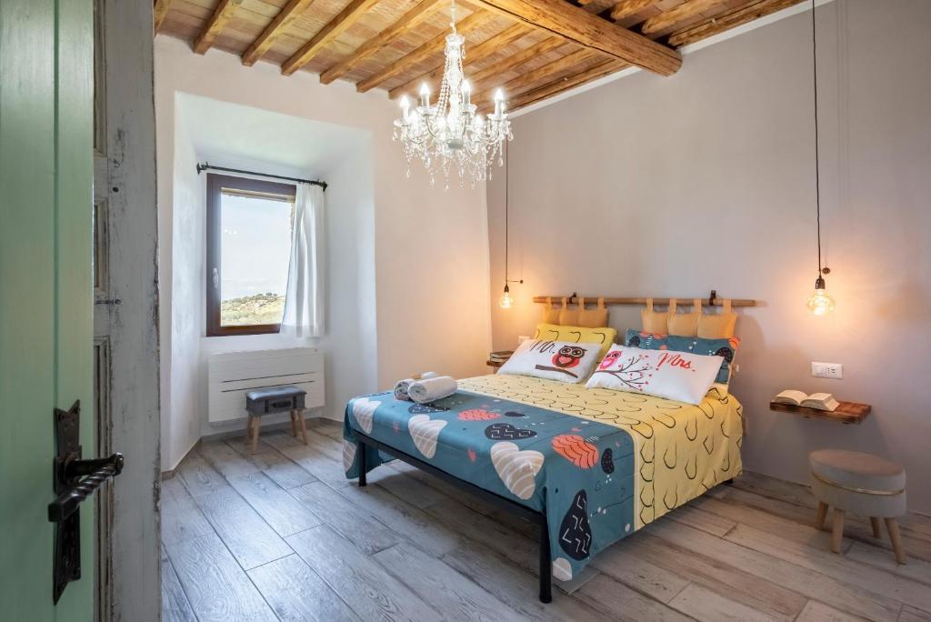 sypialnia z łóżkiem i żyrandolem w obiekcie Residenza Castello di Valli w mieście Follonica