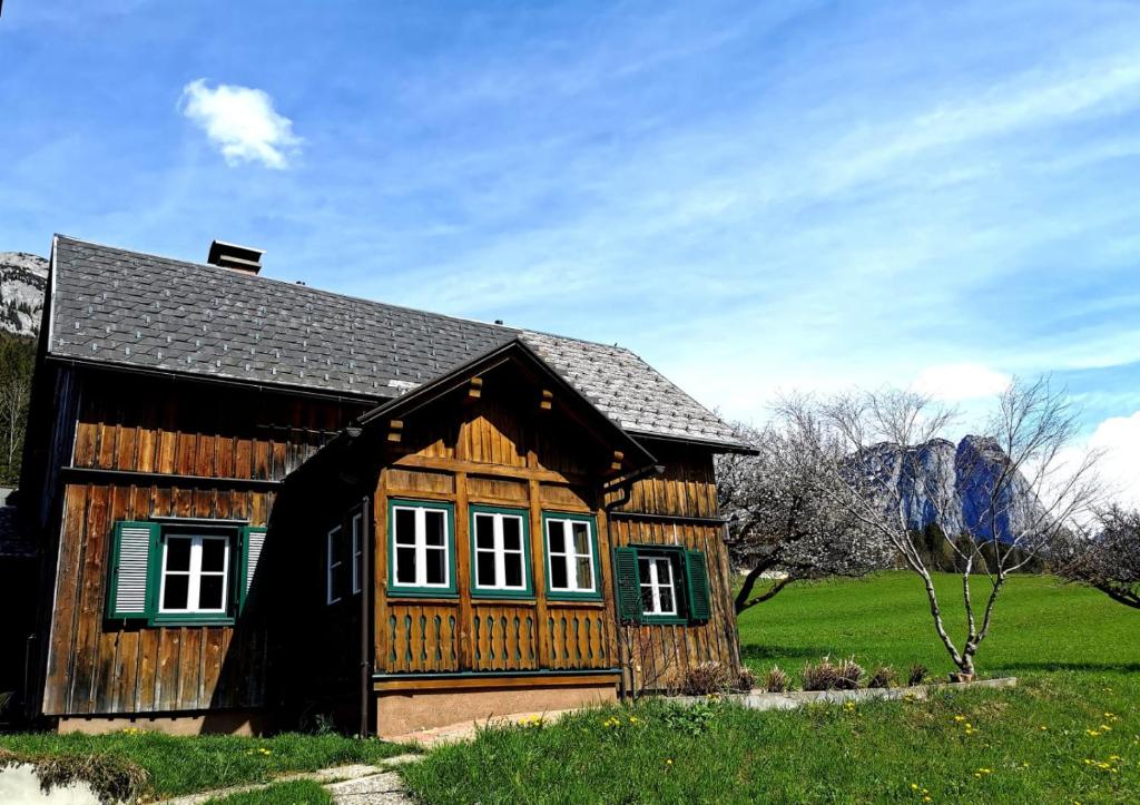 a small wooden house in a field of grass at Ferienhaus Rosl am Grundlsee in Grundlsee