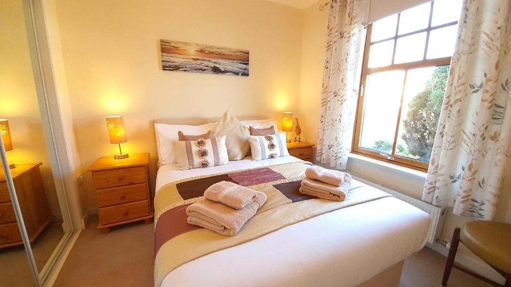 a bedroom with a bed with towels on it at Roseford Apartment in Crail