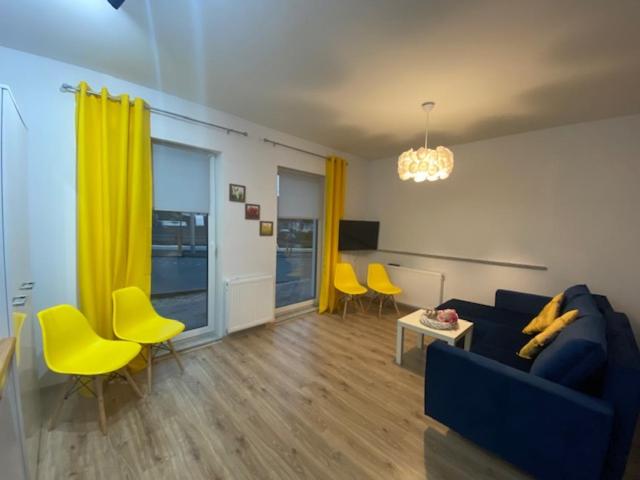 a living room with a blue couch and yellow chairs at Apartament Karpacz 2- pokojowy in Karpacz