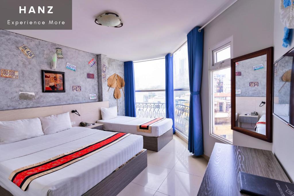 a hotel room with two beds and a window at Meraki Hotel in Ho Chi Minh City
