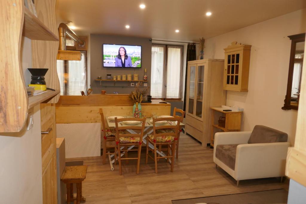 a kitchen and living room with a table and a tv at Breil centre 2pces in Breil-sur-Roya