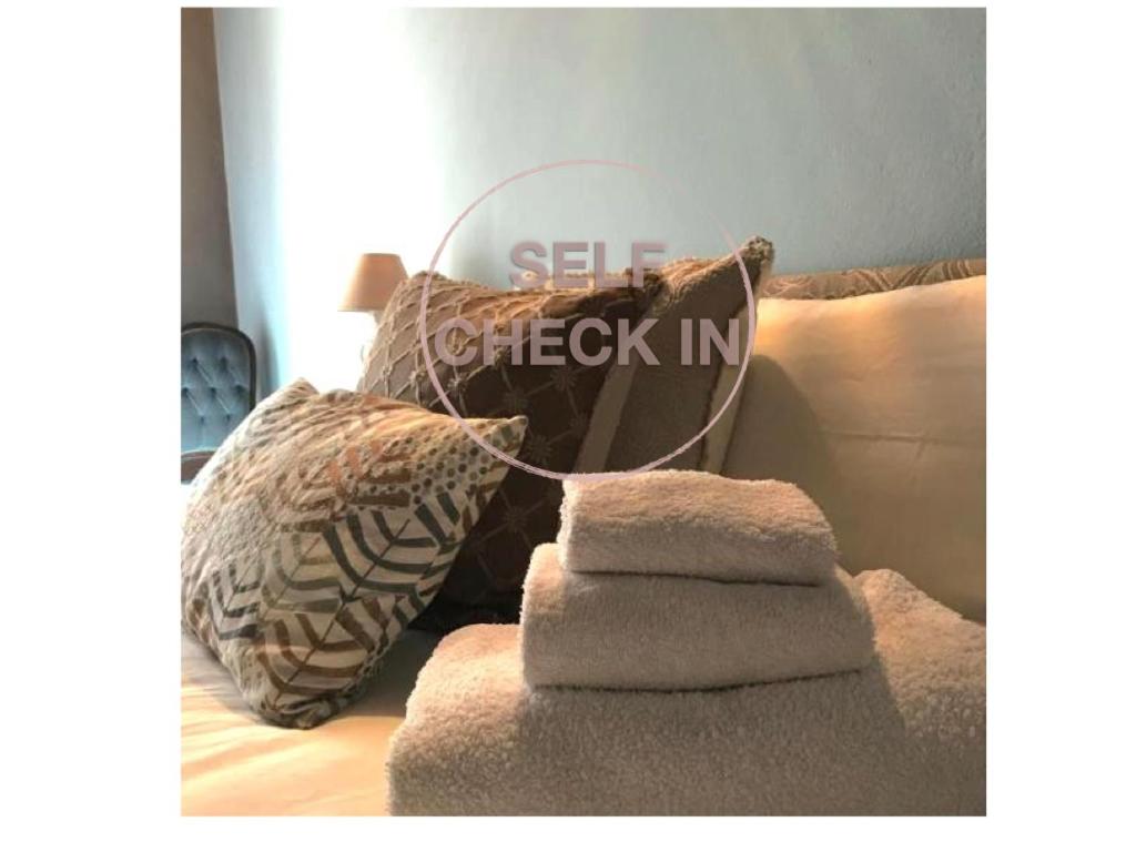 einen Haufen Handtücher, der auf einer Couch sitzt in der Unterkunft Le Camere di Bsuites Affittacamere in Parma