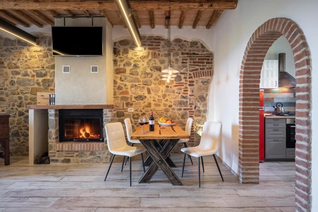 kuchnia i jadalnia ze stołem i kominkiem w obiekcie Residenza Castello di Valli w mieście Follonica