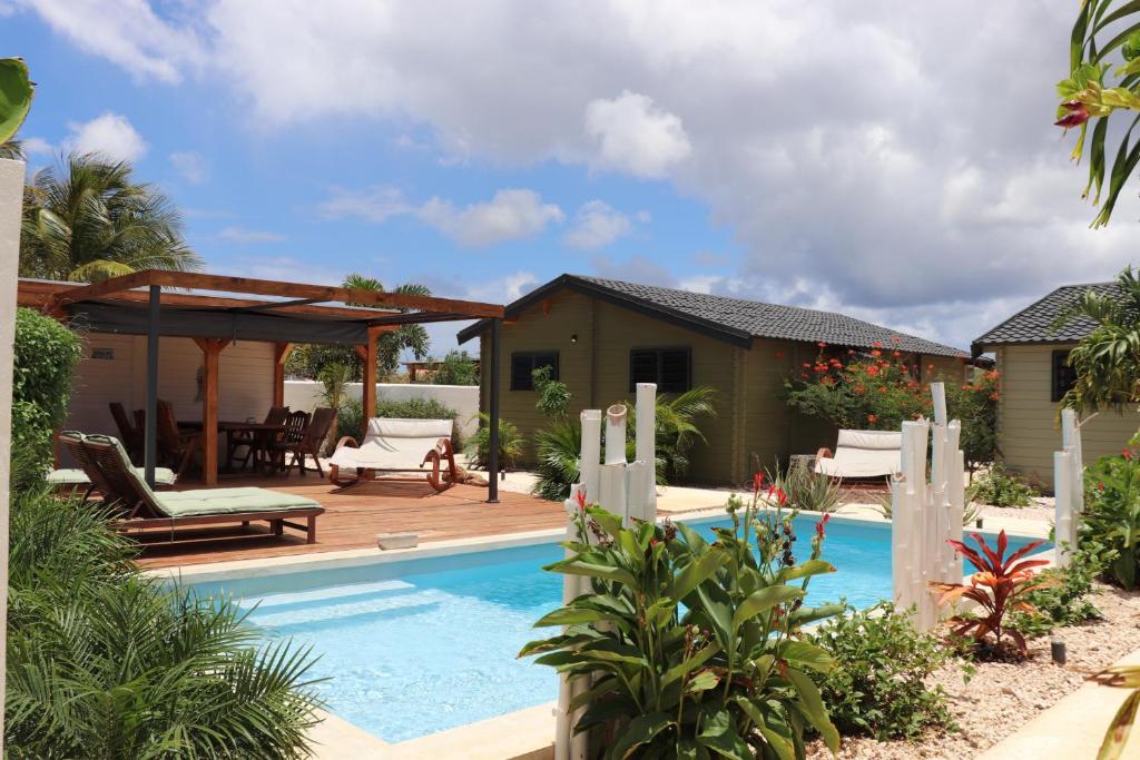 einen Hinterhof mit einem Pool und einem Haus in der Unterkunft Woodz Bonaire in Kralendijk