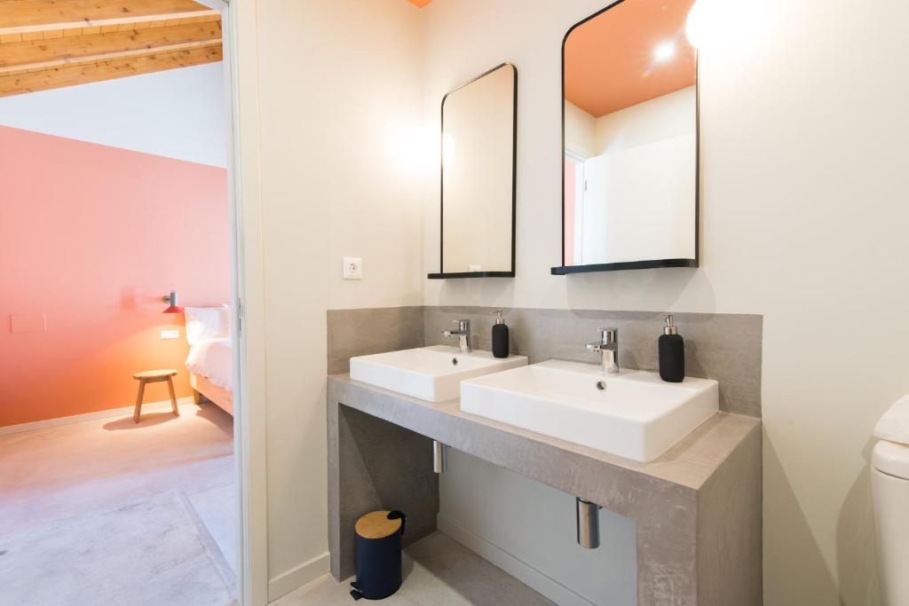 a bathroom with two sinks and a mirror at Casa Rosa Villa with Pool in Olhao Centre in Olhão