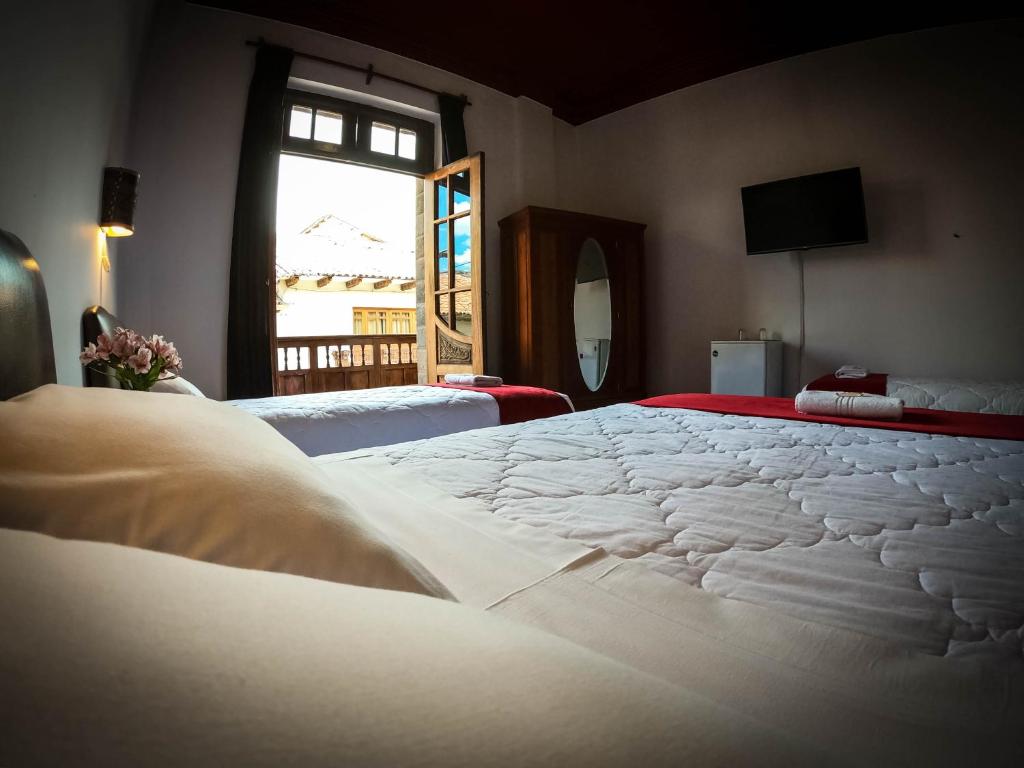 1 cama blanca grande en una habitación con ventana en Casona Santa Catalina Cusco, en Cusco