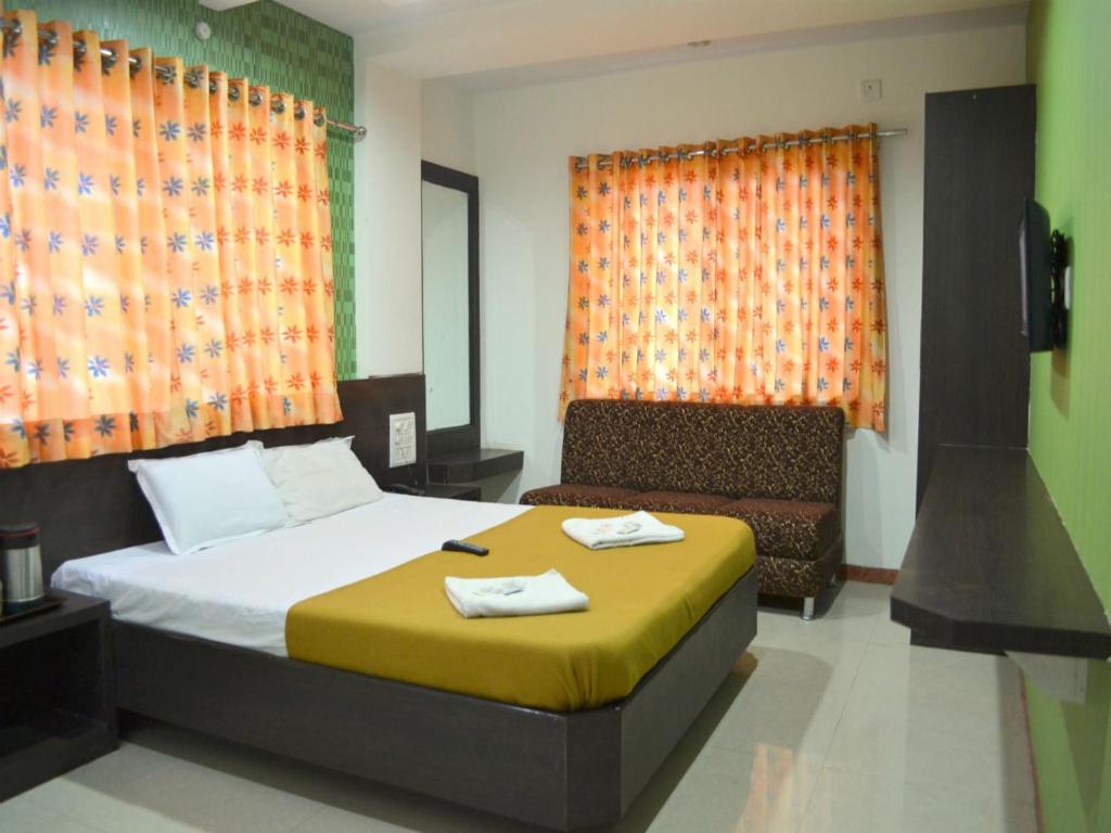 Habitación de hotel con cama y sofá en Hotel Sai Kamal en Shirdi