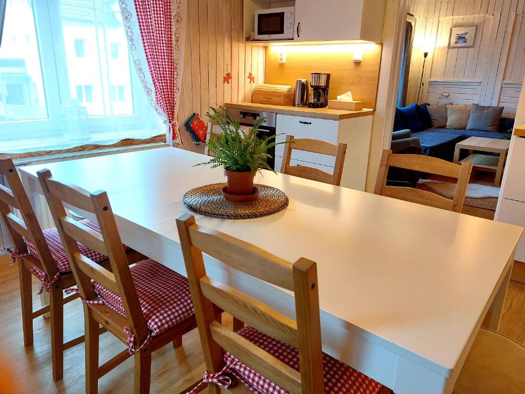 a kitchen and living room with a table and chairs at Chalupa pod stromy in Kovářská
