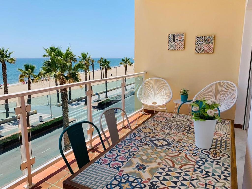 balcón con mesa, sillas y vistas al océano en Avenida Sudamerica, en Roquetas de Mar