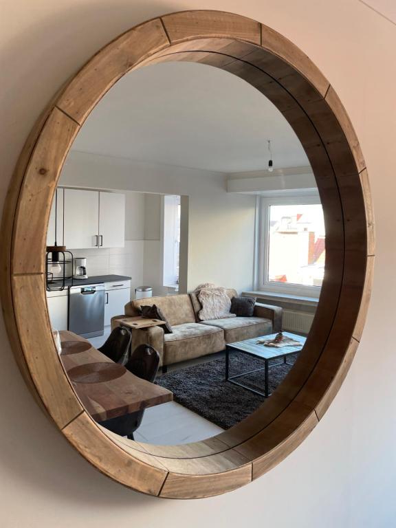 a living room with a large circular mirror on the wall at Trendy & ruim appartement centum Oostende in Ostend