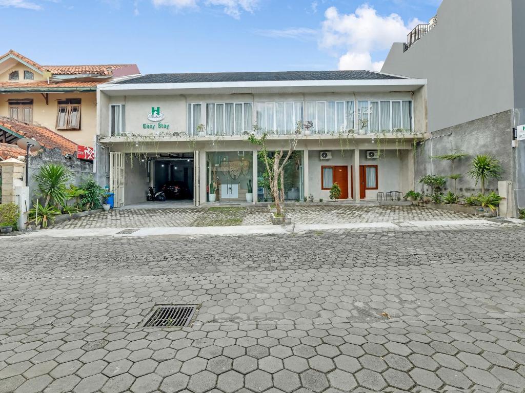 a house with a cobblestone street in front of it at Super OYO Capital O 90983 Harmony Easy Stay in Yogyakarta