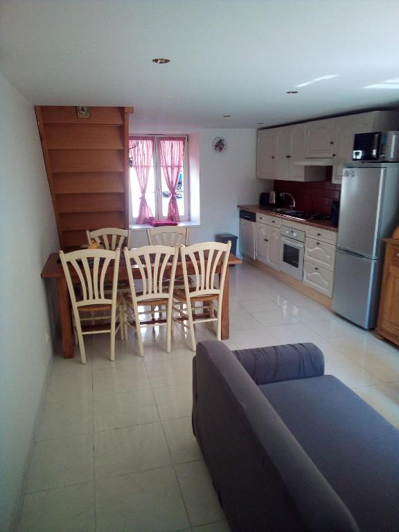 a kitchen with a couch and a table and chairs at L&#39;OASIS maisonnette centre ville 3 chambres terrasse espace vert privé parc sainte croix center parc 20 minutes in Sarrebourg