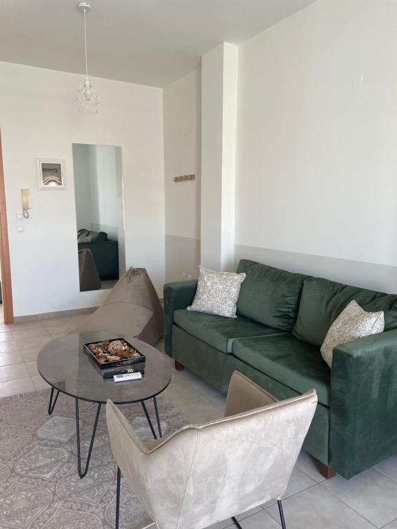 ein Wohnzimmer mit einem grünen Sofa und einem Tisch in der Unterkunft Suggrou Apartment in Thessaloniki