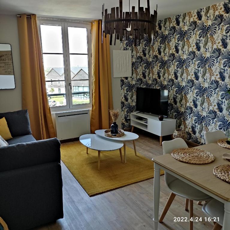 un salon avec un canapé et une télévision dans l'établissement LES MOUETTES DU PORT, à Honfleur