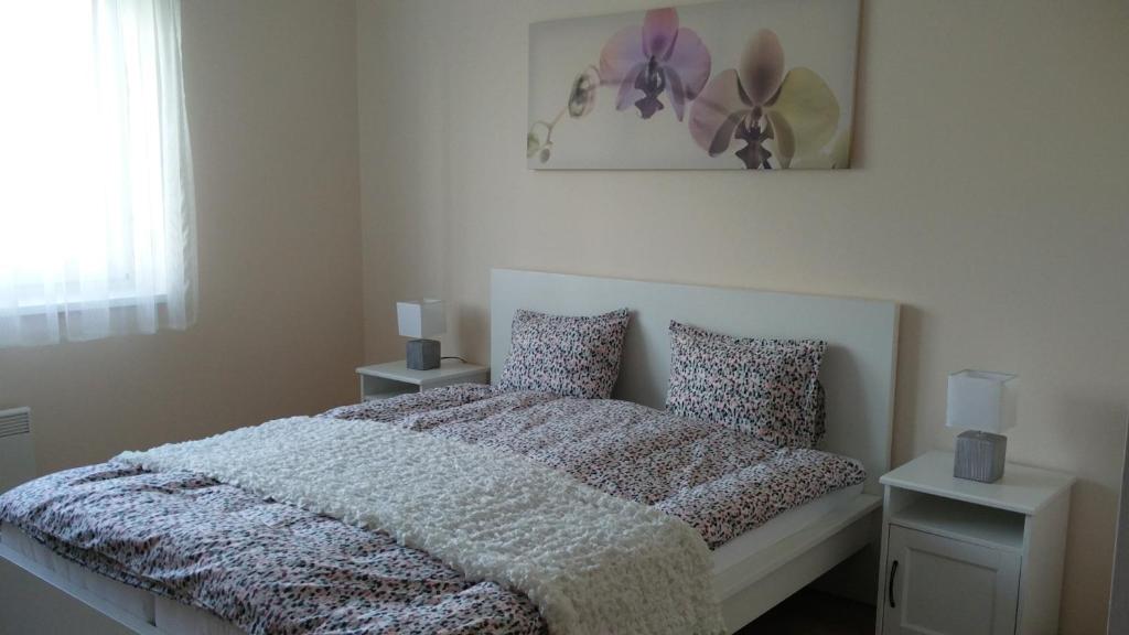 1 dormitorio con 1 cama con manta y almohadas en River Side Apartman, en Kalocsa
