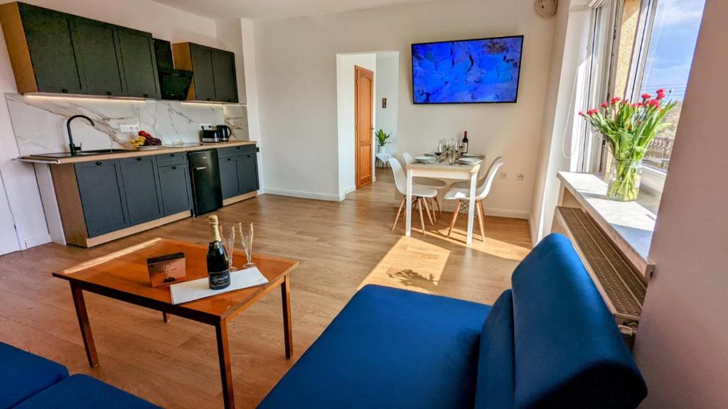 un soggiorno con divano blu e tavolo di Słoneczna Przystań - Apartament a Szczedrzyk