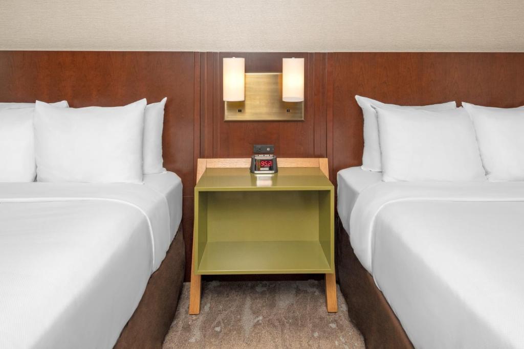 two beds in a hotel room with a table between them at Comfort Inn in Ottawa