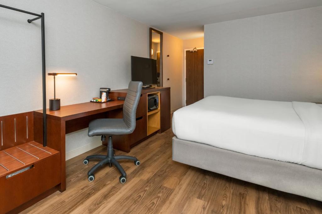 a hotel room with a bed and a desk with a computer at Comfort Inn in Ottawa