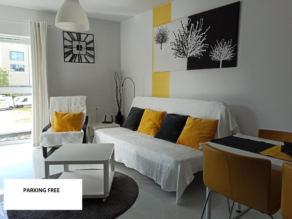 1 dormitorio con 1 cama con almohadas amarillas en Apartament Maxi, en Poznan