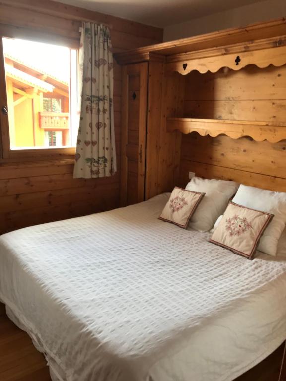 a bedroom with a large white bed with a window at Le Chamois des Alpages de Reberty ski au pied in Les Menuires