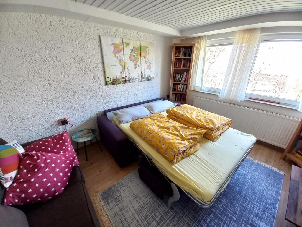 a small bedroom with a bed and a couch at FeWo Heidenheim Bluewall in Heidenheim an der Brenz