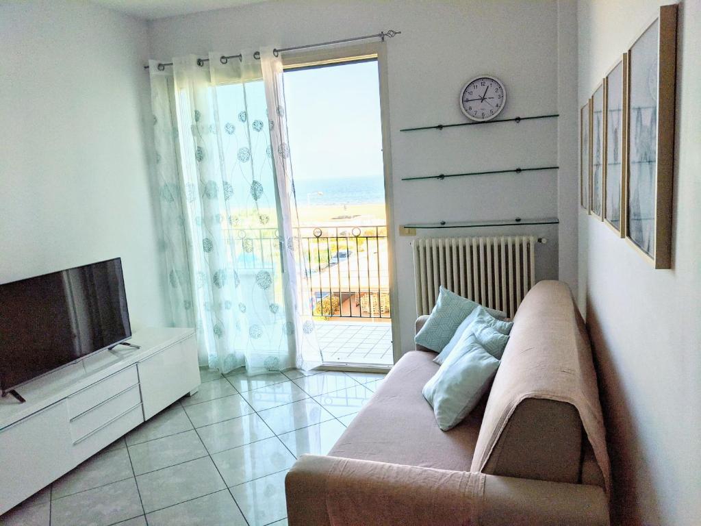 a living room with a couch and a television at Appartamento a Riccione con balconcino vista mare in Riccione