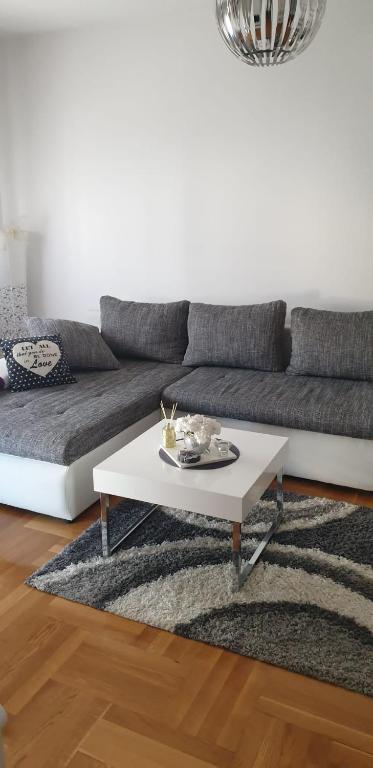 a living room with a couch and a white coffee table at Apartman Aura in Zagreb