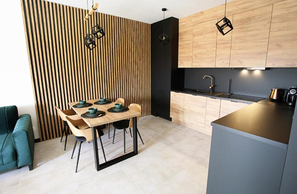 uma cozinha com uma mesa e cadeiras numa cozinha em Apartament Harmony em Olsztyn
