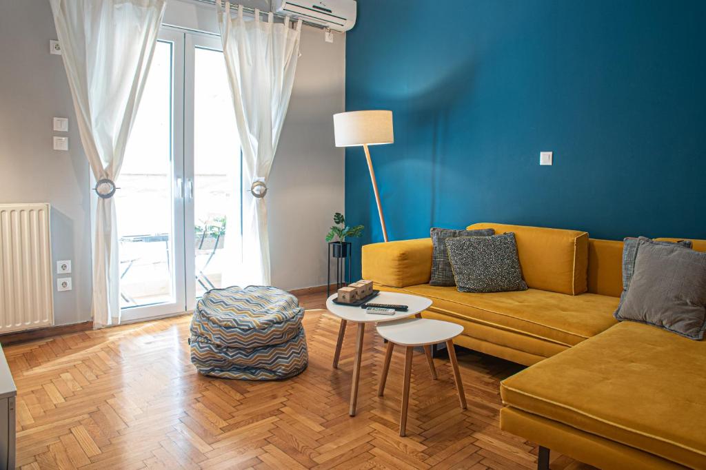 ein Wohnzimmer mit gelber Couch und blauen Wänden in der Unterkunft Maria's Home in Athen