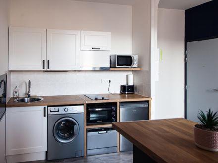 a kitchen with a washing machine and a sink at Belle Isle in Châteauroux