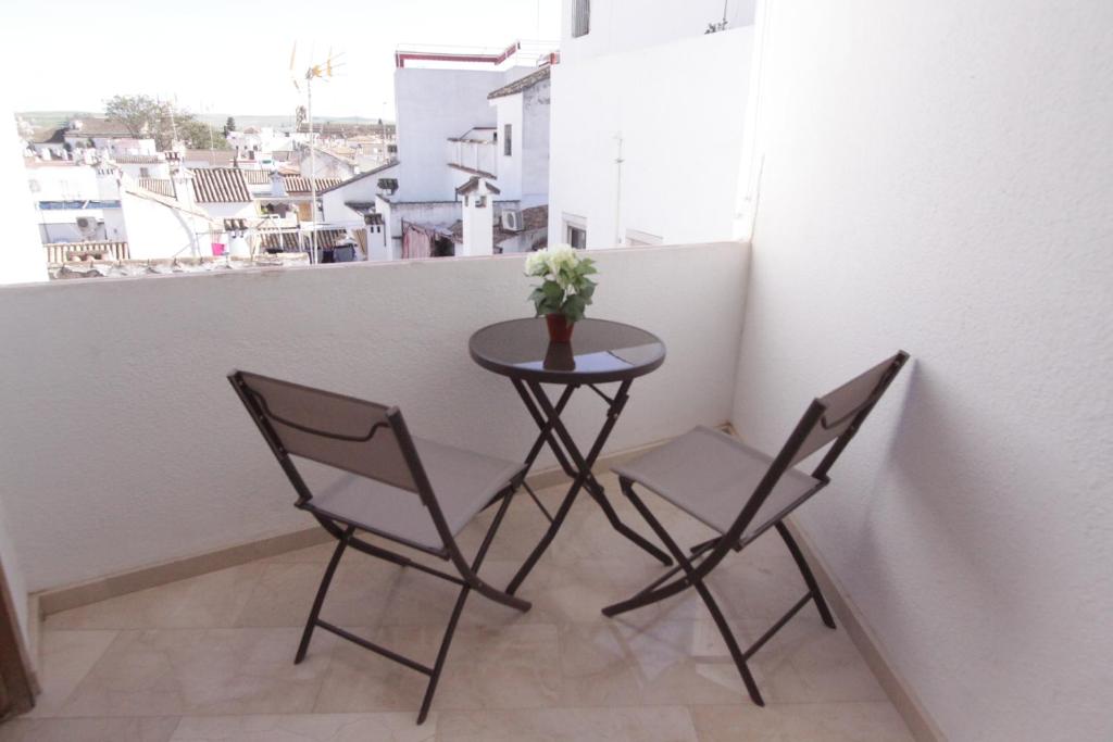 - Balcón con mesa pequeña y 2 sillas en La Regaora apartamento, en Córdoba